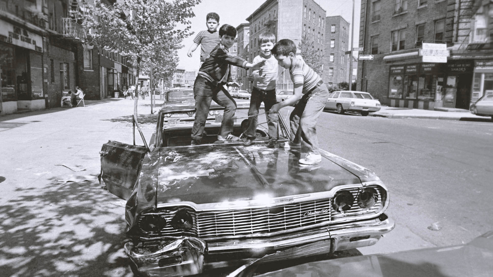 Kids playing on an abandoned car in the Bronx, NY, USA, 1975.